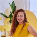 Asian woman with long wavy hear, wearing a yellow dress